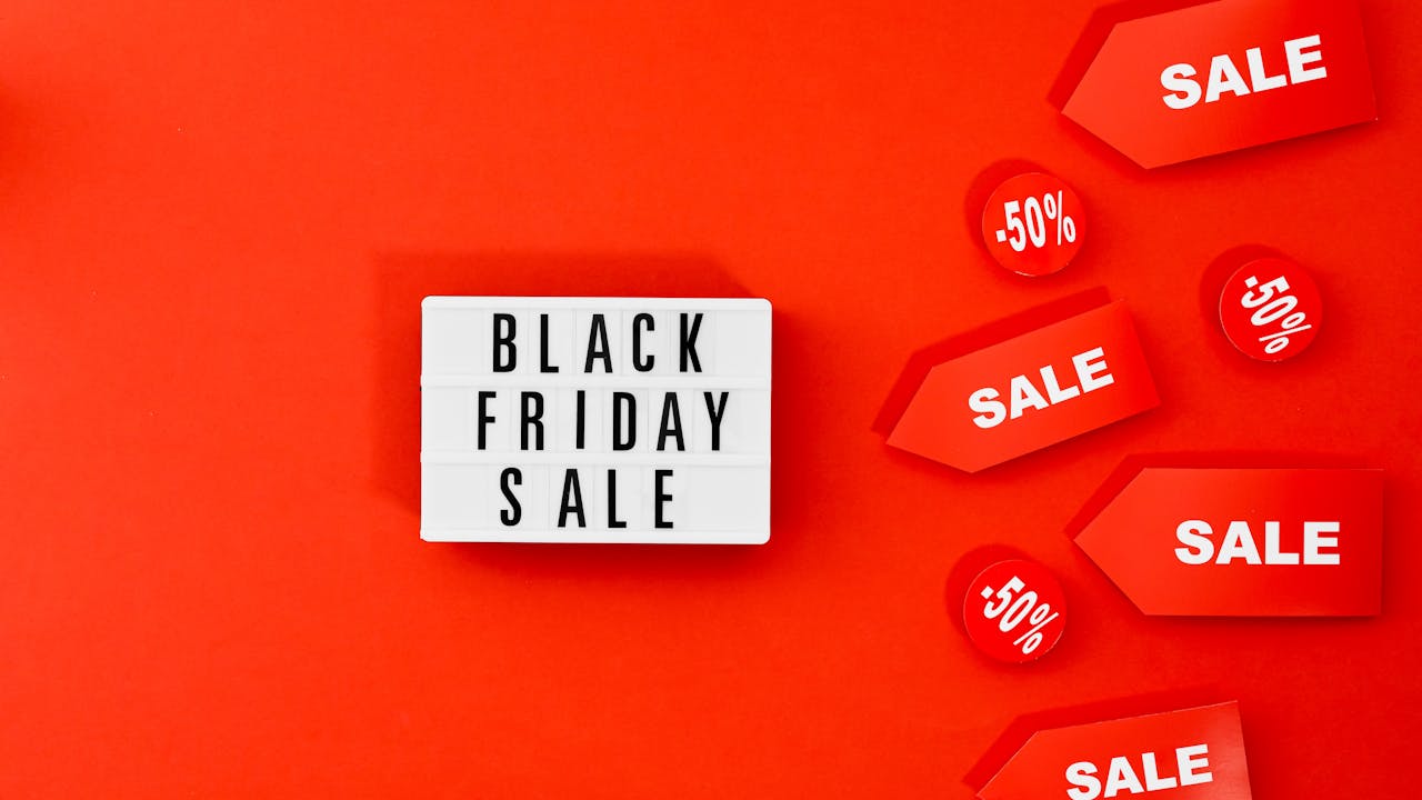 A dark background with bright neon sales tags floating.